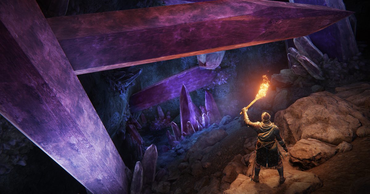 A player holding a torch in a cave full of giant purple crystals