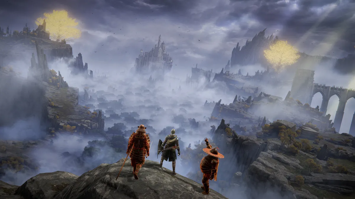 Three players standing on a rock above a misty valley with a distant castle and bridge
